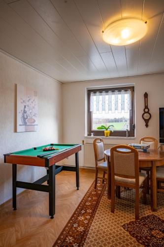 a room with a ping pong table and chairs at Ferienhaus Olbernhau 4 Sterne - Familie Walther in Olbernhau