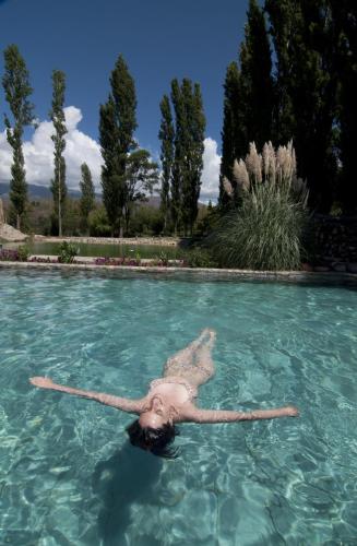 a person is floating in a pool of water at Finca Huayrapuca in Famatina