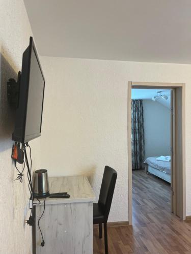 a room with a desk with a television and a bed at Soncho Gudauri in Gudauri