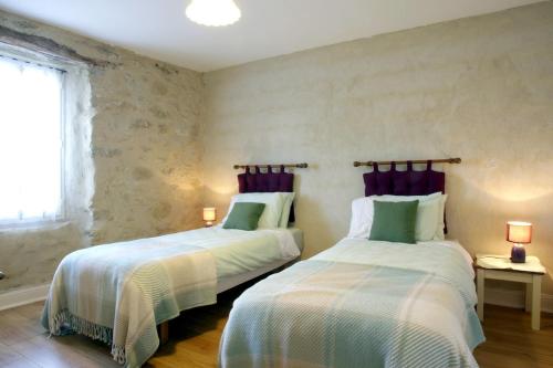 deux lits côte à côte dans une chambre dans l'établissement Argein, à Villautou