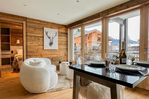 une cuisine avec une table et des chaises et une fenêtre dans l'établissement My Way Megeve village 5 rues parking, à Megève