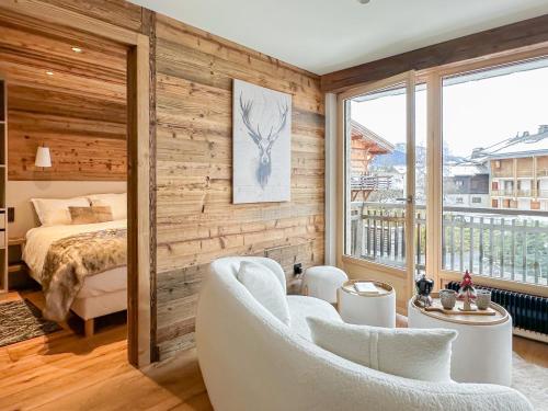 a bedroom with a bed and a large window at My Way Megeve village 5 rues parking in Megève