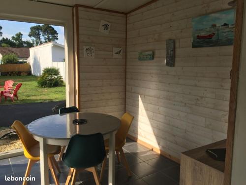 une salle à manger avec une table et des chaises et une fenêtre dans l'établissement Maison du bois, à Andernos-les-Bains