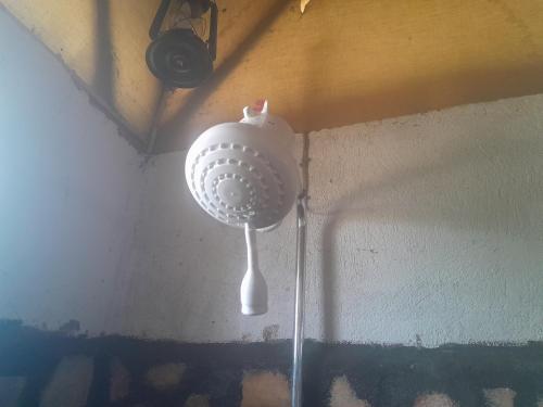 a white strainer hanging from the corner of a wall at Entale Safari Camp Queen Elizabeth National Park in Kasese