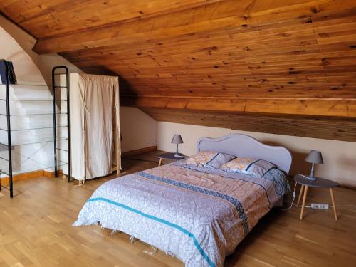 une chambre avec un lit avec un plafond en bois dans l'établissement LA PETITE MAISON, à Saint-Loup-Géanges