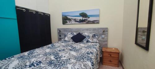 une chambre avec un lit avec une couette bleue et blanche dans l'établissement Appartement Cap D'Agde le Pharo, au Cap d'Agde