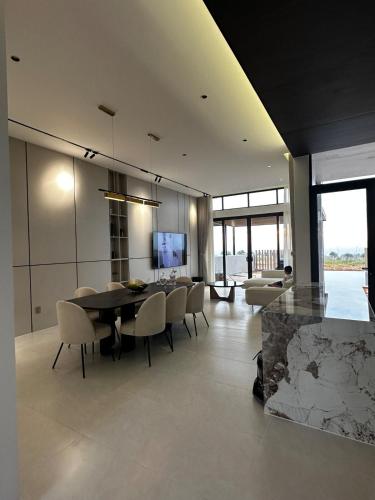 a dining room and living room with a table and chairs at Villa Golf Novaworld in Bình Sum