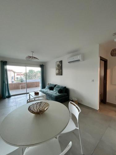 un salon avec une table, des chaises et un canapé dans l'établissement Apartment 1 Favone, beach 100m away, à Conca