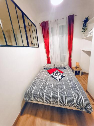 Ce lit se trouve dans un dortoir doté de rideaux rouges. dans l'établissement Studio T1 Centre - Idéal couple & amis - Confort - WIFI - Calme - Climatisation - Coin Terrasse, à Nice