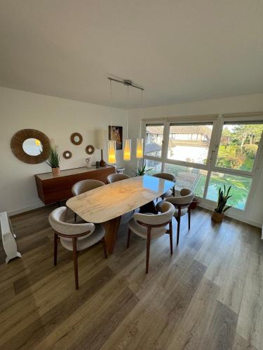 une salle à manger avec une table et des chaises en bois dans l'établissement 4 pieces 80m2, plage 7 mn a pied, parking gratuit, à Benerville-sur-Mer