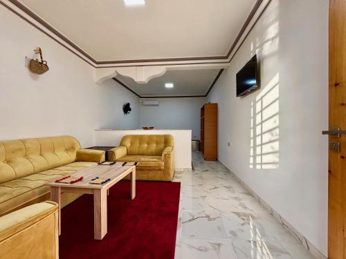 a living room with a couch and a table at Complexe Kariat Ayoub in Aït Zat