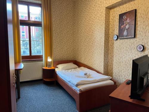 a small bedroom with a bed and a window at Hotel i Restauracja Castle in Bystrzyca Kłodzka