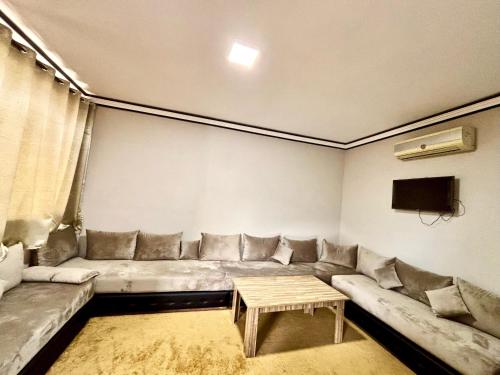 a living room with a couch and a table at Complexe Kariat Ayoub in Aït Zat