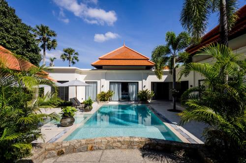 a swimming pool in front of a villa at Luxury 4 Bedroom Villa 1 Minute from Laguna Phuket in Bang Tao Beach