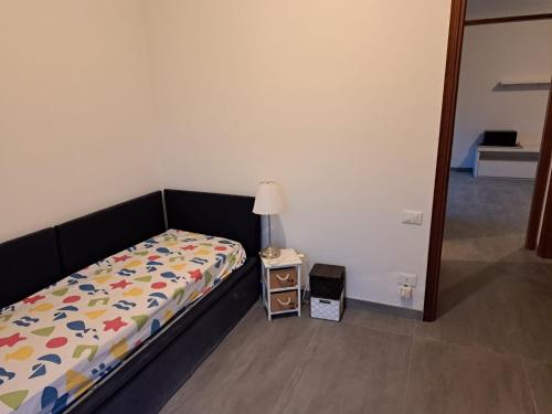 une chambre avec un lit et une table avec une lampe dans l'établissement Casa Mare Massa Pinete, à Marina di Massa