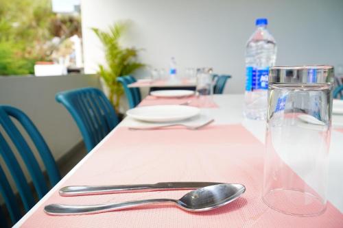 a table with a pink table cloth and a plate and spoon at The Clouds End in Devikolam