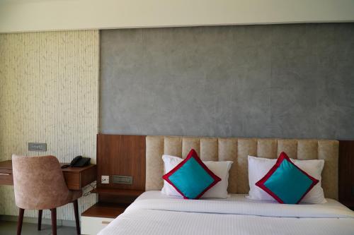 a bedroom with a bed with two colorful pillows at The Clouds End in Devikolam
