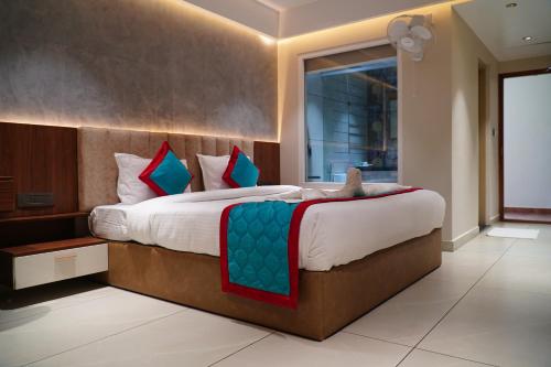 a bedroom with a large bed with a large window at The Clouds End in Devikolam