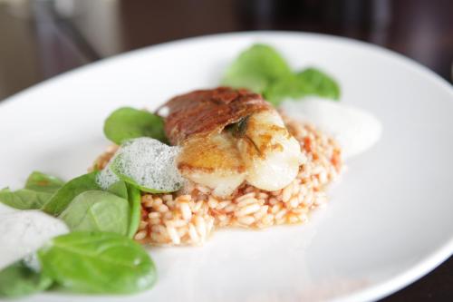 a white plate of food with rice and vegetables at La Cucina - Hotel & Restaurant in Peggau