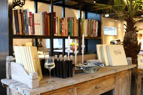 a wooden table with books and a glass of wine at La Cucina - Hotel & Restaurant in Peggau