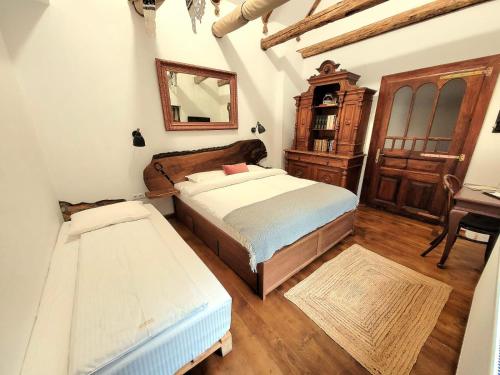 a bedroom with a bed and a dresser and a mirror at Joyard - Pensiune & Parc in Porumbacu de Sus