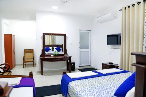 a hotel room with two beds and a desk at Ronaka Airport Transit Hotel in Katunayake