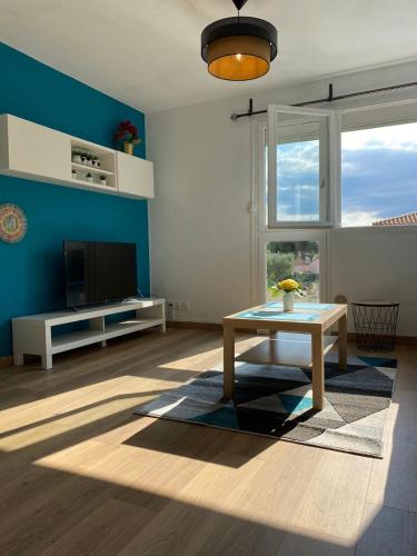un salon avec une table et une télévision dans l'établissement Bel appartement côté Port avec Piscine & Tennis proche Plage, à Saint Cyprien Plage