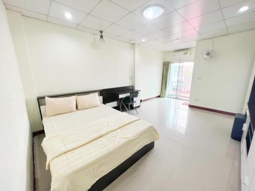 een slaapkamer met een bed en een bureau erin bij Jaroon House in Samutprakarn