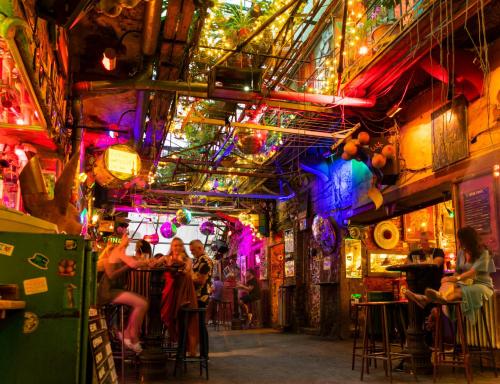 a group of people sitting at tables in a bar at Little Americas Wyoming Lodge Apartment in Budapest