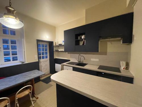 une cuisine avec un évier et un plan de travail dans l'établissement Appart COQUET Intra-Muros façade historique rez de chaussée terrasse, à Saint-Malo