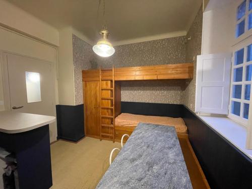 ein kleines Zimmer mit einem Etagenbett und einem Tisch in der Unterkunft Appart COQUET Intra-Muros façade historique rez de chaussée terrasse in Saint-Malo