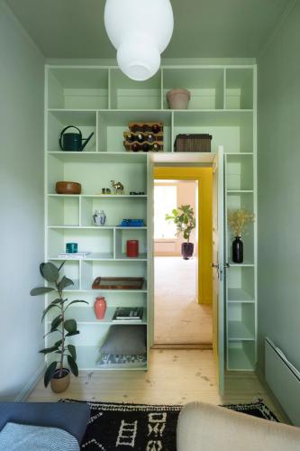a room with green shelves and a yellow door at The Residence in Oslo