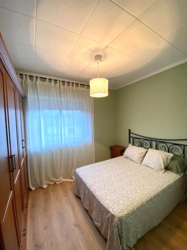 a bedroom with a bed and a large window at A casa da Sia in Ribadeo