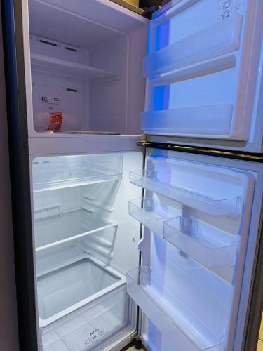 an open refrigerator with its door open and its shelves at Casa Sonora Dunas Secure Parking in San Luis Río Colorado
