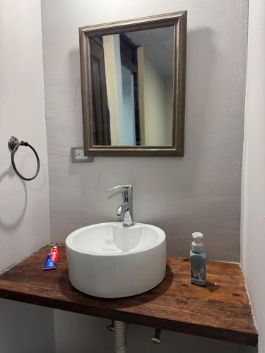 a bathroom sink with a mirror on a wooden counter at Casa Sonora Dunas Secure Parking in San Luis Río Colorado