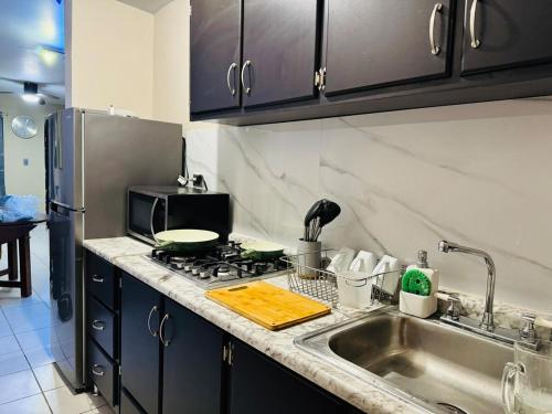 a kitchen with a sink and a stove top oven at Casa Sonora Dunas Secure Parking in San Luis Río Colorado