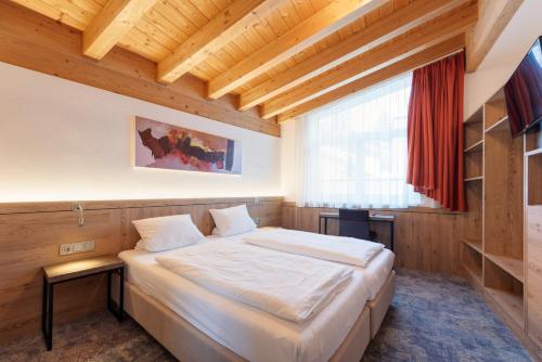 Posteľ alebo postele v izbe v ubytovaní Hotel Alpenland