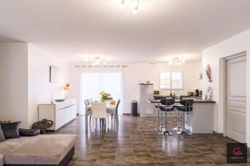 Il comprend un salon et une cuisine avec une table et des chaises. dans l'établissement Biscarrosse Bourg Maison tout confort proche du centre ville, à Biscarrosse