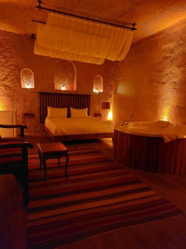 a bedroom with a bed and a tub in it at Grand Uchisar Hotel in Uchisar