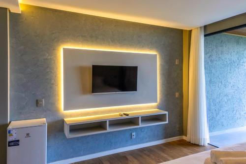 a living room with a tv on a wall at Mansão VOAR in Florianópolis