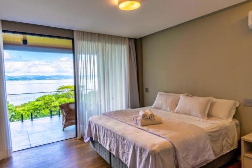 a bedroom with a bed with a view of the ocean at Mansão VOAR in Florianópolis