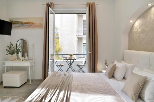a white bedroom with a bed and a balcony at Alekos Apartments 2 Netflix, Self Check-In in Athens
