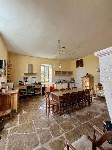 a large kitchen with a large table and chairs at Chambres d'hôtes au Château de Gandillac in Saint-Martial-Viveyrol