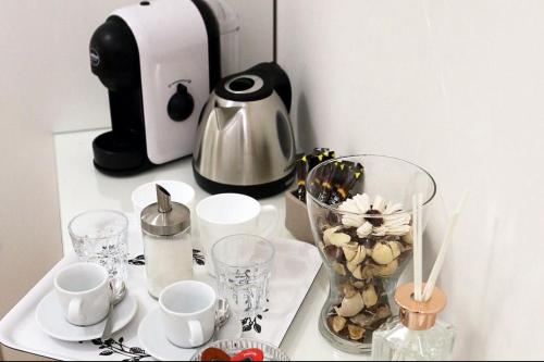 una mesa con tazas y tazas y una cafetera en House 5 minutes walk from Vatican Museums, en Roma