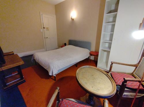 a small room with a bed and chairs in it at De la Maison Restau' à la Chambre en particulier in Voreppe
