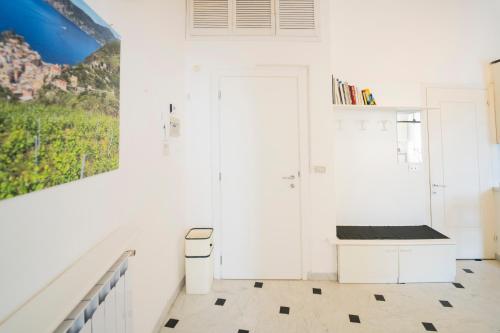 a white room with a staircase and a door at La Casa di Eroico Vino in Vernazza