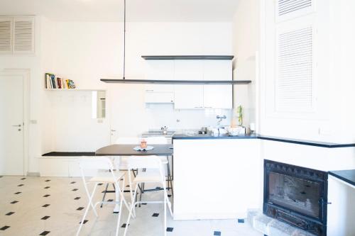 a white kitchen with a table and a fireplace at La Casa di Eroico Vino in Vernazza