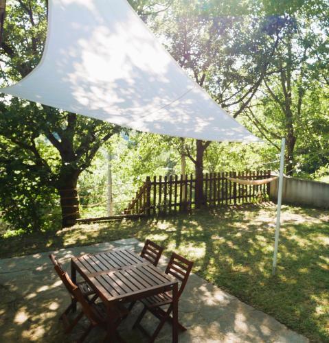 a picnic table and chairs under a white umbrella at Cool Natural Relax at Alivé Home&Garden in Sassello