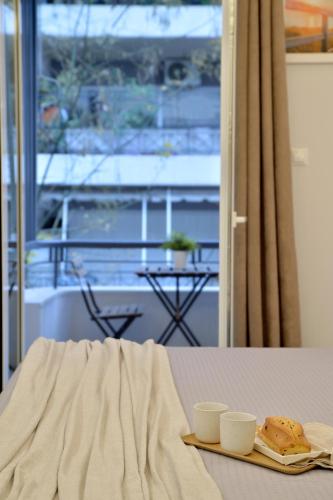 a table with two cups and a plate of food at Alekos Apartments 2 Netflix, Self Check-In in Athens