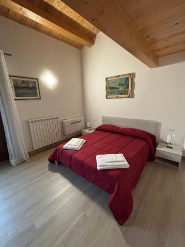 a bedroom with a red bed with two towels on it at Dream House Castellana in Castellana Sicula